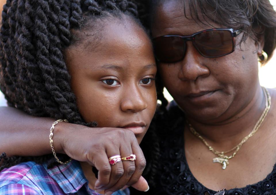 Antonee Martin, left, and her mother Latrechia Jackson, right, visit the memorial site set up in front of the Emanuel AME Church, Thursday, June 18, 2015 in Charleston, S.C. Martin said her aunt Susie Jackson was one of the victims in the shooting Wednesday night at the church. (AP Photo/Stephen B. Morton)