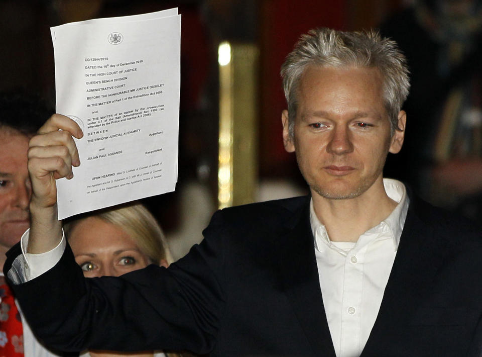 FILE - In this Thursday, Dec. 16, 2010 file photo, WikiLeaks founder Julian Assange holds up a court document for the media after he was released on bail, outside the High Court in London. Judge Vanessa Baraitser has ruled that Julian Assange cannot be extradited to the US. because of concerns about his mental health, it was reported on Monday, Jan. 4, 2021. Assange had been charged under the US's 1917 Espionage Act for "unlawfully obtaining and disclosing classified documents related to the national defence". (AP Photo/Kirsty Wigglesworth, file)