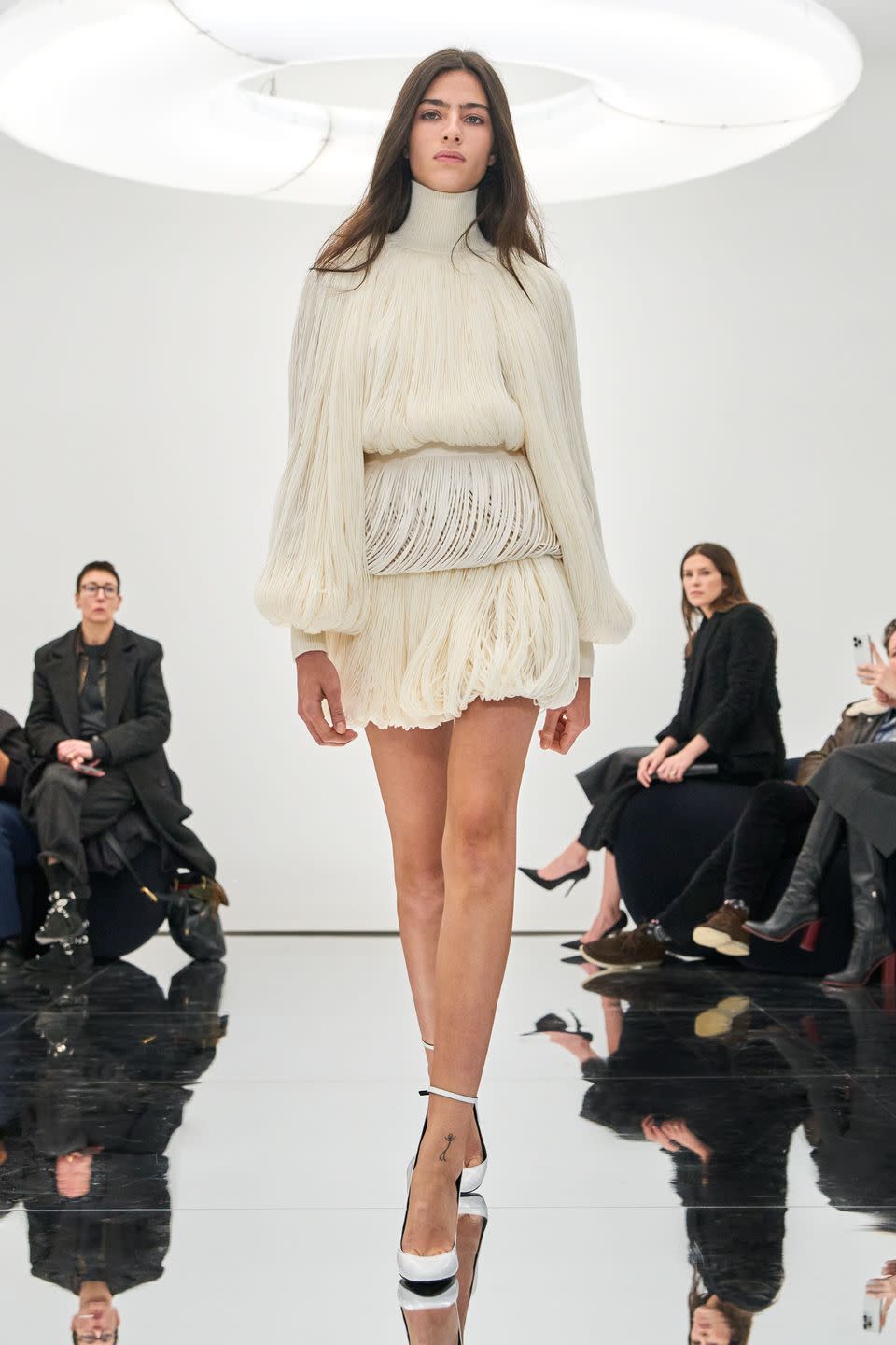 a model in a white alaia couture minidress with a bubble hem