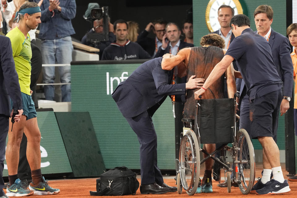 Spain's Rafael Nadal, left, watch Germany's Alexander Zverev being helped to sit on a wheelchair during their semifinal match of the French Open tennis tournament at the Roland Garros stadium Friday, June 3, 2022 in Paris. (AP Photo/Michel Euler)