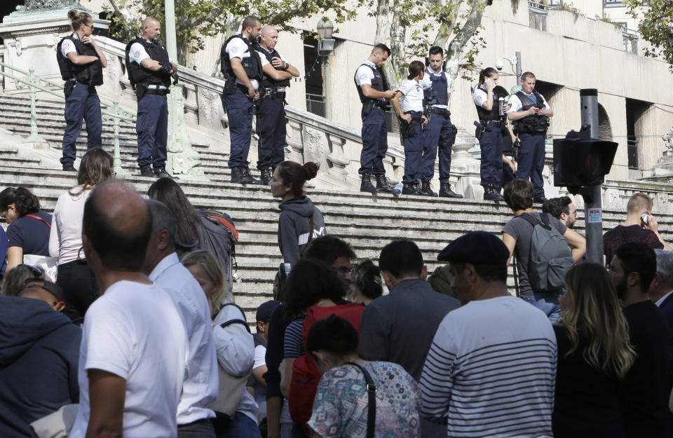 Passengers wait in front a line a police officers blocking the access to Marseille ‘s main train station. (AP Photo/Claude Paris)