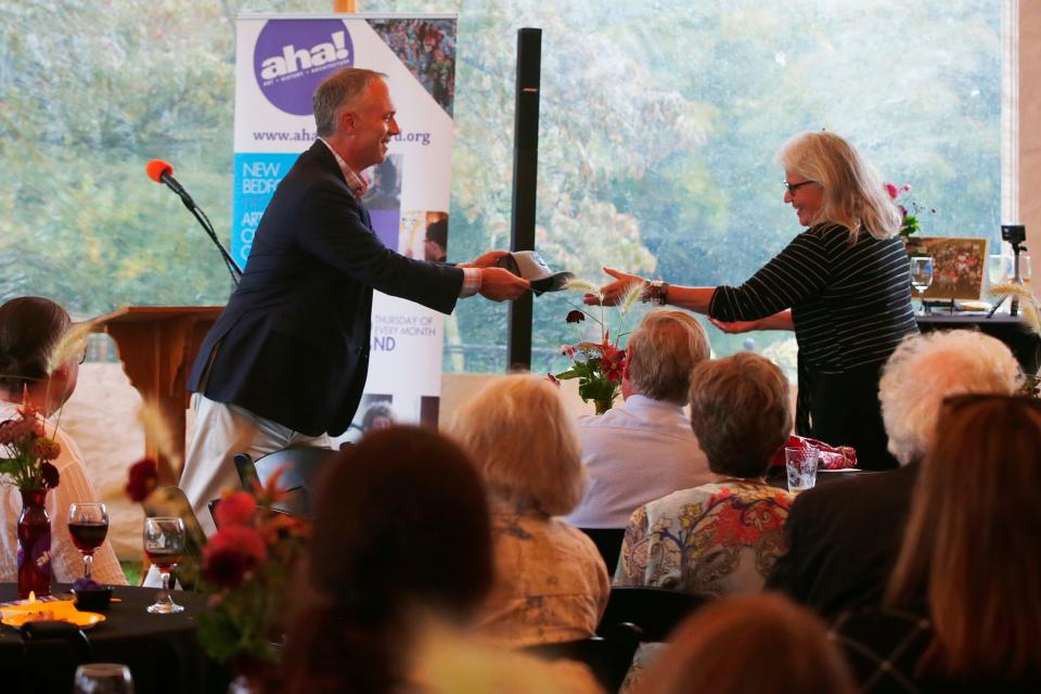 Mayor Jon Mitchell gives AHA! program director, Candace Lee Heald a Port of New Bedford hat at her retirement party held at the Rotch Jones Duff House in New Bedford.