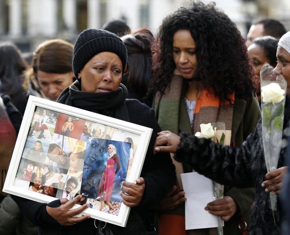 People who lost family members in the Grenfell Tower fire hold photographs of their loved ones outside the memorial service at St Paul’s Cathedral.