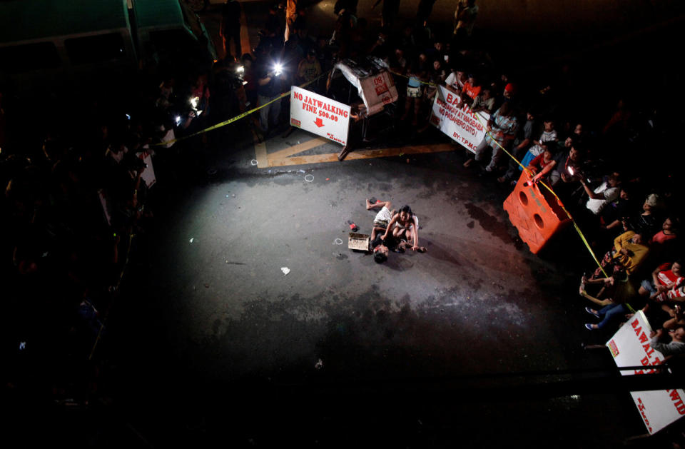 A woman weeps over the body of her husband, who was killed on the street