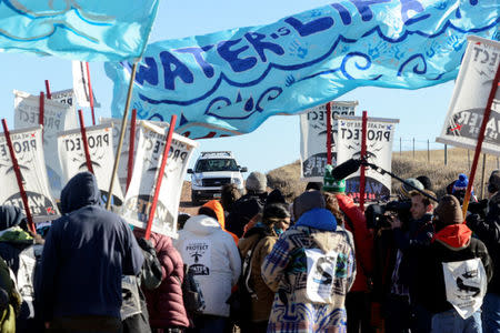 Protesters lock arms during a standoff with a police car along the pipeline route during a protest against the Dakota Access pipeline near the Standing Rock Indian Reservation in St. Anthony, North Dakota, U.S. November 11, 2016. REUTERS/Stephanie Keith