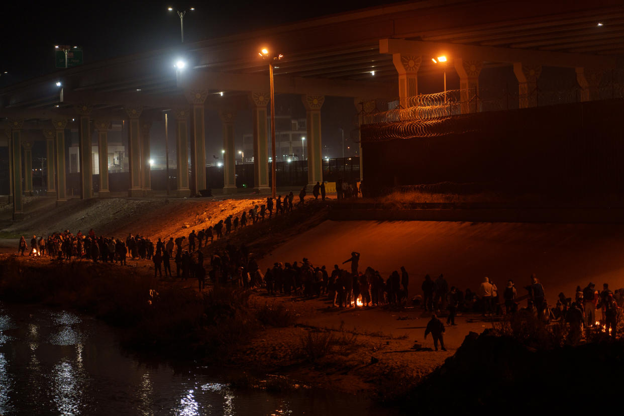 Migrantes, en su mayoría de Nicaragua, se mantienen calientes junto a fogatas mientras esperan en fila en la frontera entre Estados Unidos y México en El Paso, Texas, el 11 de diciembre de 2022. (Paul Ratje/The New York Times)
