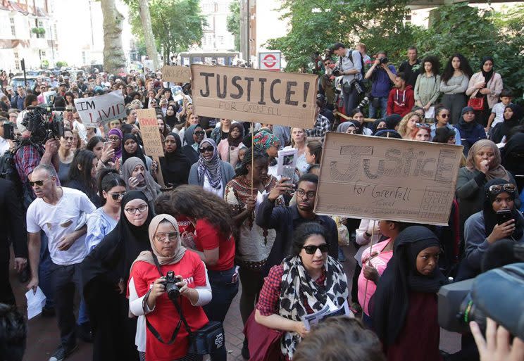 Protesters hold placards outside Kensington and Chelsea town hall