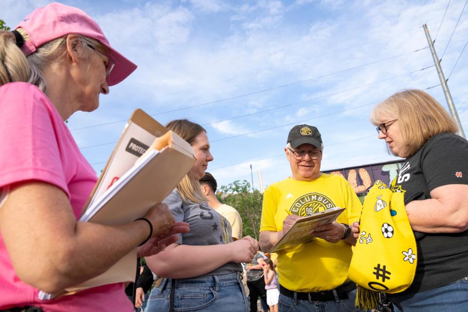 May 13, 2023; Columbus, Ohio, USA;  Right to left, Eileen Ferree, Marc Ferree and Jennifer Ferree sign a petition for putting a ballot issue about enshrining abortion rights into the state constitution before voters in November 2023. "I just think it's important for a woman to be able to choose what they do with their bodies," said Jennifer Ferree.