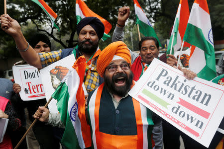 People hold national flags and placards as they celebrate after Indian authorities said their jets conducted airstrikes on militant camps in Pakistani territory, in New Delhi, India, February 26, 2019. REUTERS/Adnan Abidi