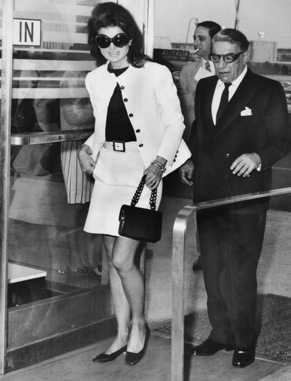 <p>A matching jacket-and-skirt set paired with a small black handbag and black leather heels make for an elegant outfit for bidding Aristotle Onassis goodbye at the Kennedy Airport.<br></p>