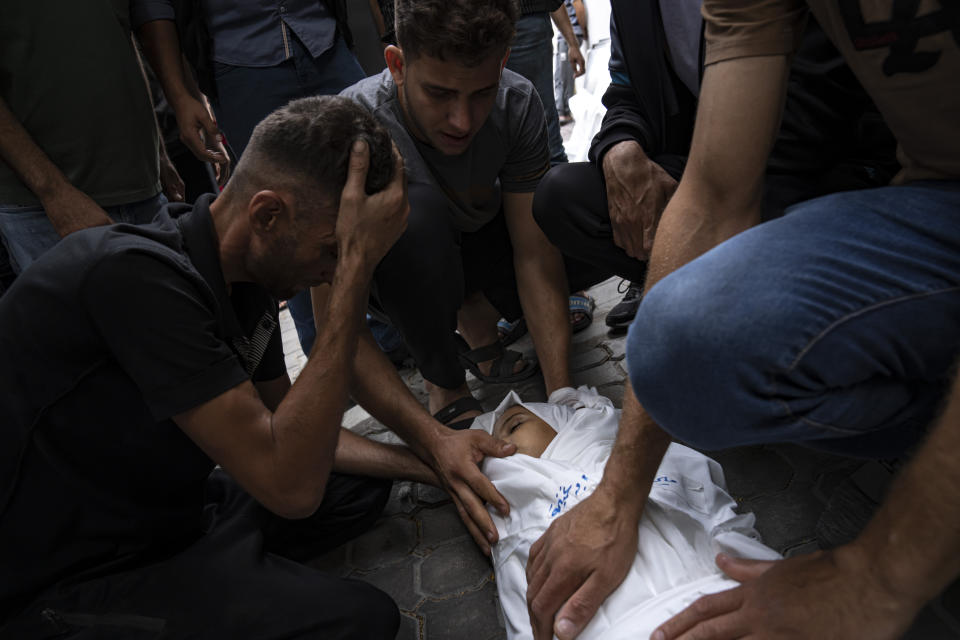 A relative mourns over a girl killed in an Israeli air strike in Gaza City on Monday, Oct. 9, 2023. Israel's military battled to drive Hamas fighters out of southern towns and seal its borders Monday as it pounded the Gaza Strip. (AP Photo/Fatima Shbair)