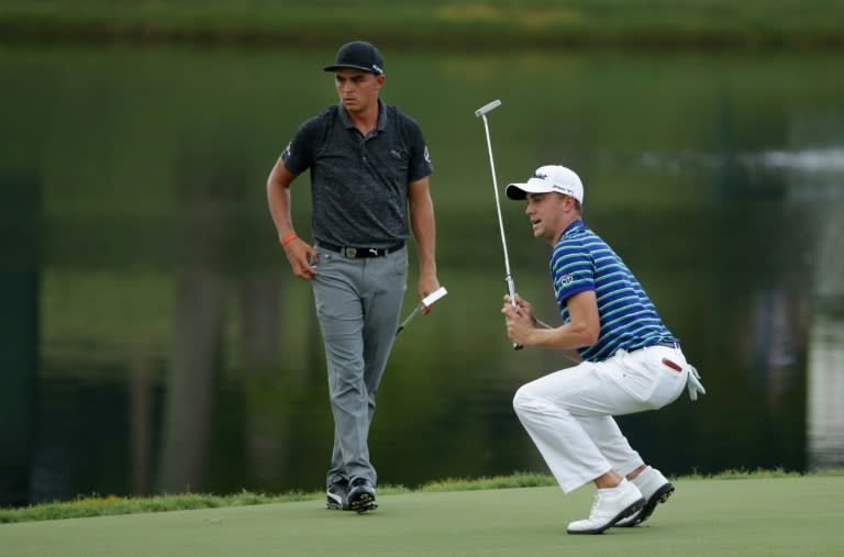 Justin Thomas of the US (R) reacts to his putt on the 17th green as compatriot Rickie Fowler looks on, during the third round of the 2017 PGA Championship at Quail Hollow Club in Charlotte, North Carolina, on August 12