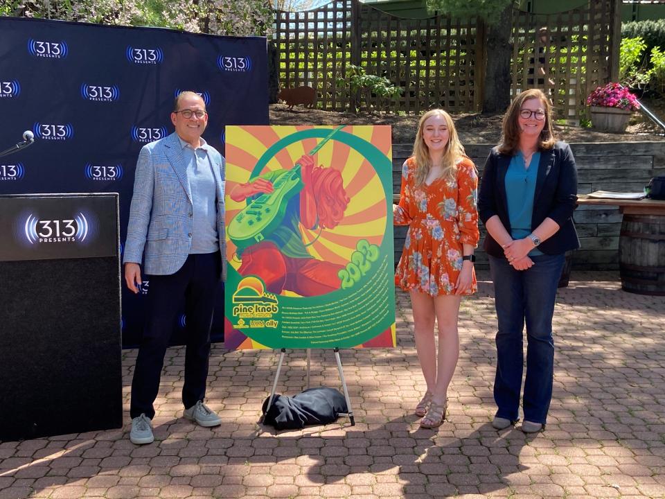 Alison Slatka (center), a student at Detroit's College for Creative Studies, poses with her winning concert poster design at Pine Knob Music Theatre on May 11, 2023. She's joined by 313 Presents president Howard Handler (left) and CCS marketing director Megan Mesack.