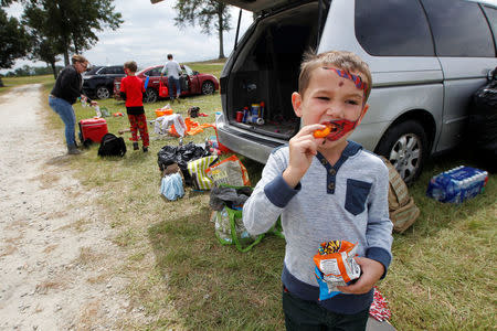 Five-year old Owen Hendon snacks as his family from Vero Beach, Florida begin packing up their car after sleeping in a tent and being offered a condo to sleep in to get away from Hurricane Irma at Atlanta Motor Speedway in Hampton, Georgia, U.S., September 10, 2017. REUTERS/Tami Chappell