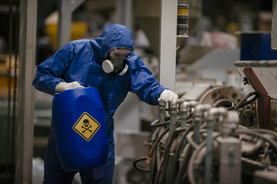 A person in a hazmat suit working in waste management