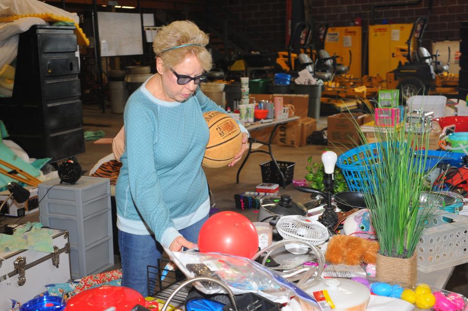 Willa Birckbichler decides on items available for sale during the annual "Trash to Treasure" sale Thursday, May 19, 2022, at the University of Mount Union Physical Plant. A variety of items were available for purchase, with proceeds to benefit community projects in Alliance.