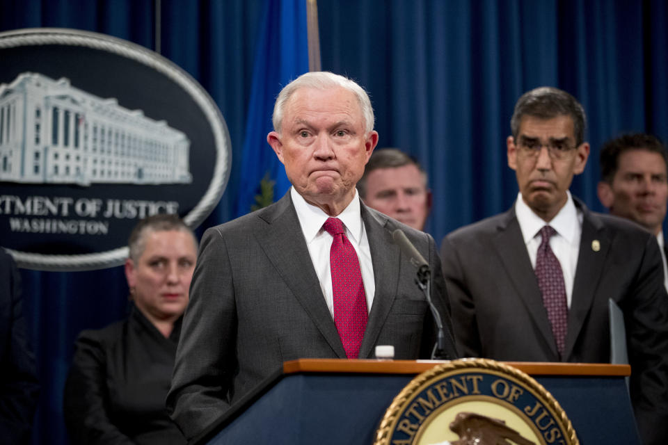 Attorney General Jeff Sessions accompanied by accompanied by Drug Enforcement Administration Acting Administrator Uttam Dhillon, right, and other officials from the Drug Enforcement Administration, State Department, Treasury Department, Internal Revenue Service and Immigration and Customs Enforcement, pauses while speaking during a news conference to announce enforcement efforts against Cartel Jalisco Nueva Generacion, Tuesday, Oct. 16, 2018, at the Justice Department in Washington. (AP Photo/Andrew Harnik)