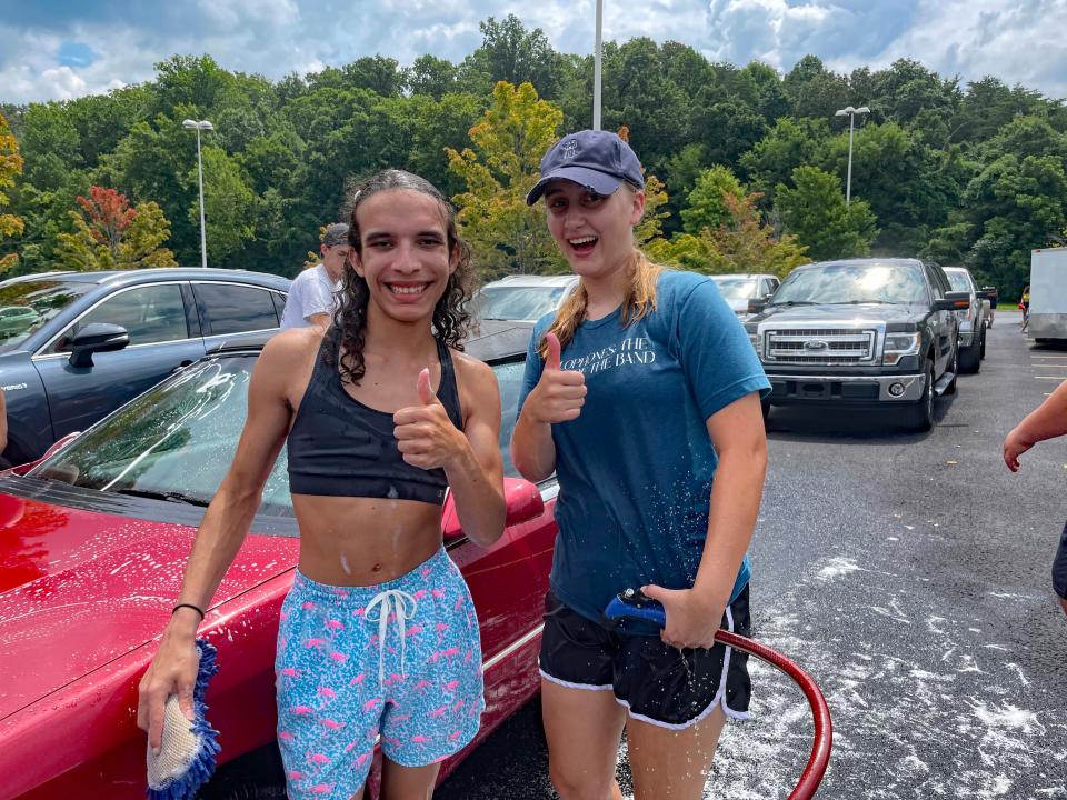 Hardin Valley Academy marching band members Ara Berrio and Nora Smith say they’re having a great time while raising money for a trip to Disney World at the annual car wash fundraiser at Food City on Middlebrook Pike Saturday, July 22, 2023.