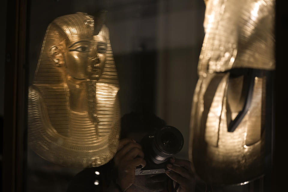 A visitor films a recently displayed golden funerary mask of king Psusennes I, at the Egyptian museum in Cairo, Egypt, Monday, Feb. 20, 2023. Egypt's ministry of tourism and antiquities unveiled a renovated wing within its 120-year-old museum, the first stage of a broader replenishment program for the palatial building. (AP Photo/Amr Nabil)