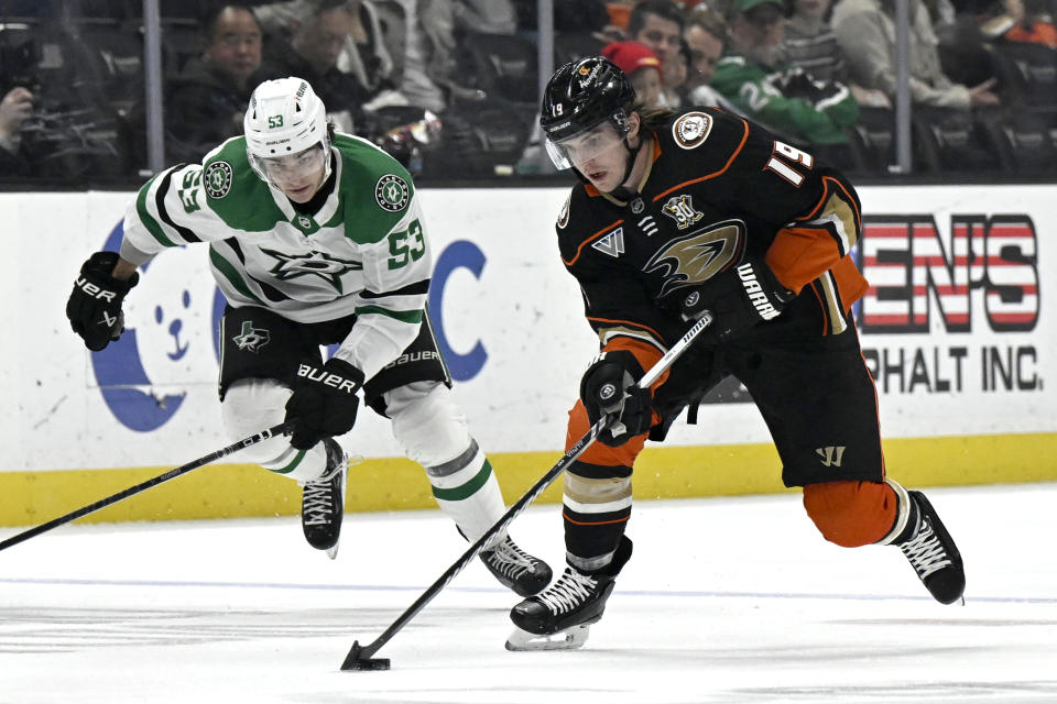 Anaheim Ducks right wing Troy Terry (19) controls the puck with Dallas Stars center Wyatt Johnston (53) in pursuit during the first period of an NHL hockey game in Anaheim, Calif., Friday, March 8, 2024. (AP Photo/Alex Gallardo)