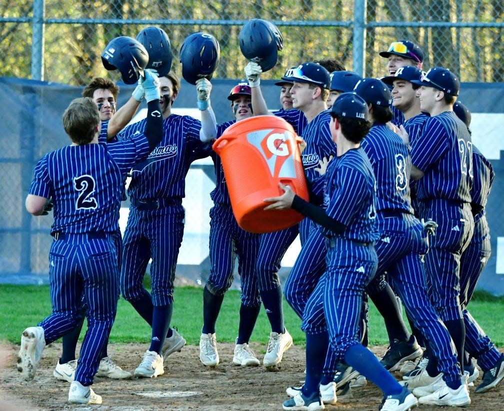 St. Thomas Aquinas senior Timmy Avery (2) is greeted at home plate by his teammates after his game-winning, three-run walk-off homer in Tuesday's 11-8 win over Division I Timberlane.