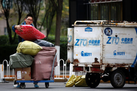 A man unloads parcels from a vehicle of a ZTO Express delivery in Beijing, China, October 27, 2016. REUTERS/Thomas Peter