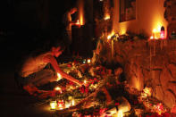 REFILE CLARIFYING CAPTION People light candles at the Malaysian embassy for victims of Malaysia Airlines MH17, which crashed in eastern Ukraine, in Kiev July 17, 2014. REUTERS/Valentyn Ogirenko