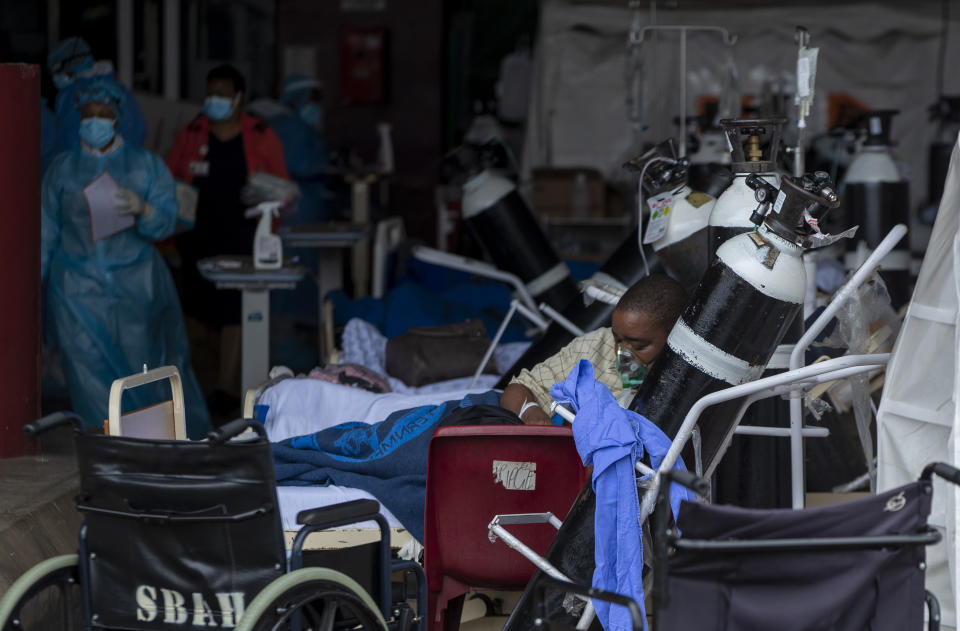 A patient wearing an oxygen mask is being treated in makeshift emergency units at Steve Biko Academic Hospital in Pretoria, South Africa, Monday, Jan. 11, 2021, which is battling an ever-increasing number of Covid-19 patients. (AP Photo/Themba Hadebe)