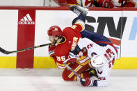 Calgary Flames' Noah Hanifin, left, falls to the ice with Washington Capitals' Tom Wison during the second period of an NHL hockey game Tuesday, March 8, 2022, in Calgary, Alberta. Hanifin was called for interference. (Larry MacDougal/The Canadian Press via AP)