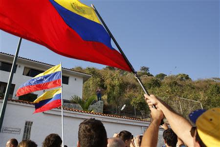 Angel Vivas (C), an anti-Maduro retired army general, talks to people gathered outside his house after he resisted being detained in Caracas February 23, 2014. According to local media, President Nicolas Maduro ordered the detention of Vivas on Saturday. REUTERS/Carlos Garcia Rawlins