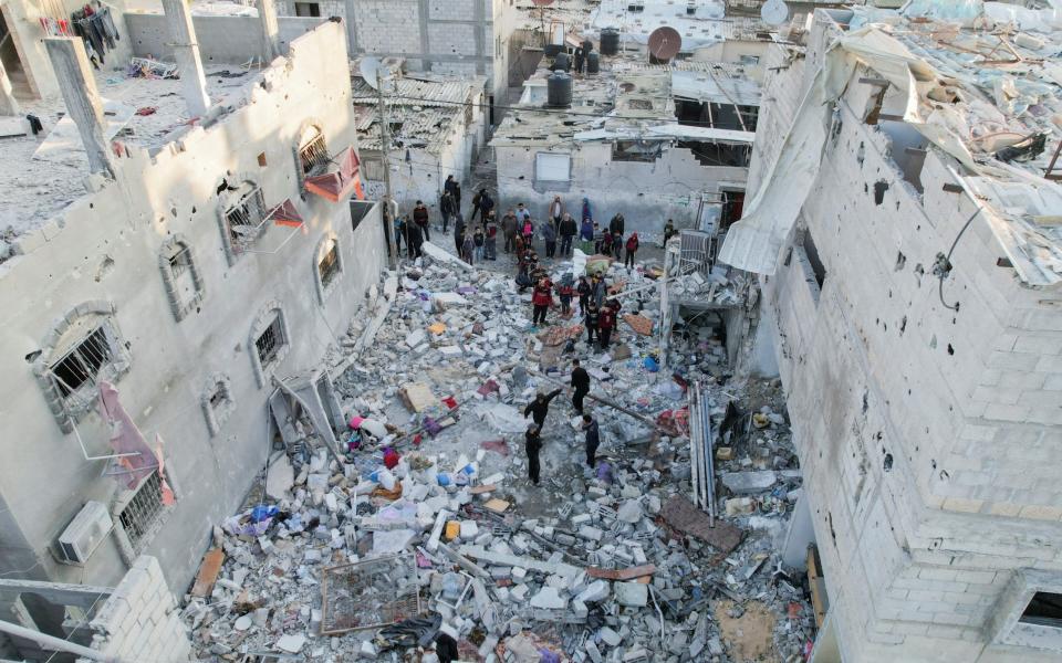 Palestinians gather at the site of an Israeli strike on a house in Rafah