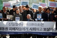 Lee Choon-shik, a victim of wartime forced labor during the Japanese colonial period, arrives with supporters holding portraits of fellow deceased laborers in Seoul, South Korea, October 30, 2018. The banner reads "Nippon Steel & Sumitomo Metal Corp apologize to wartime forced labors and compensate them". REUTERS/Kim Hong-Ji