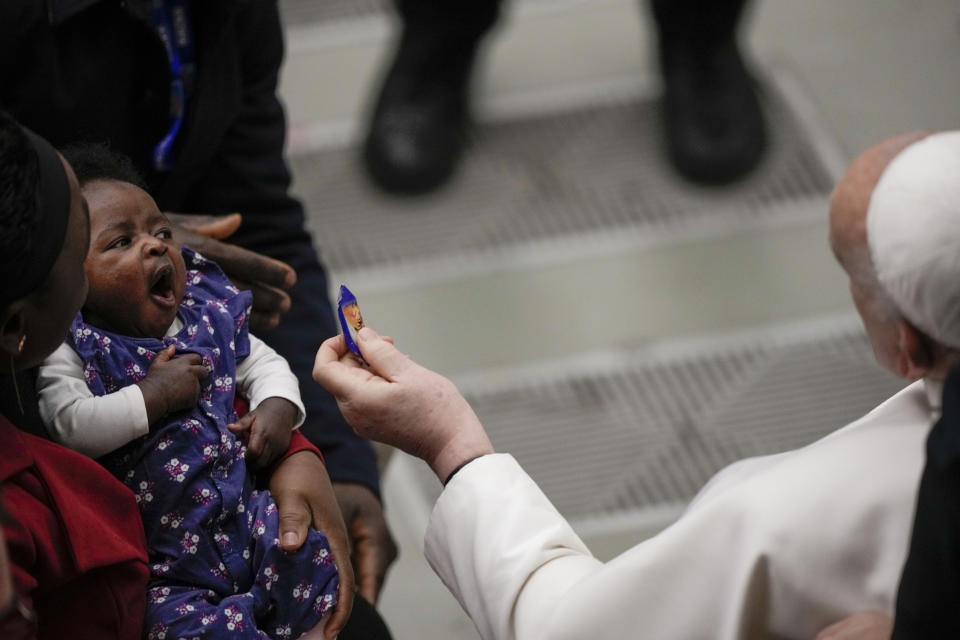 Pope Francis offers a child a sweet during his weekly general audience in the Pope Paul VI hall at the Vatican, Wednesday, Jan. 24, 2024. (AP Photo/Andrew Medichini)