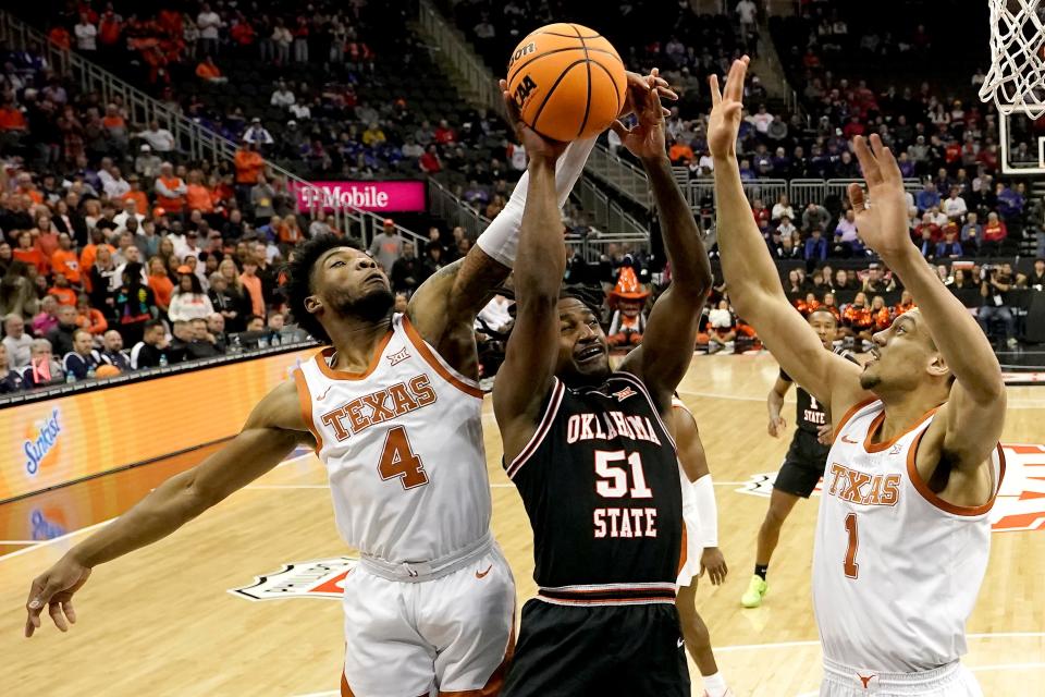 Oklahoma State guard John-Michael Wright (51) shoots under pressure from Texas guard Tyrese Hunter (4) and forward Dylan Disu (1) during the first half of an NCAA college basketball game in the second round of the Big 12 Conference tournament Thursday, March 9, 2023, in Kansas City, Mo. (AP Photo/Charlie Riedel)