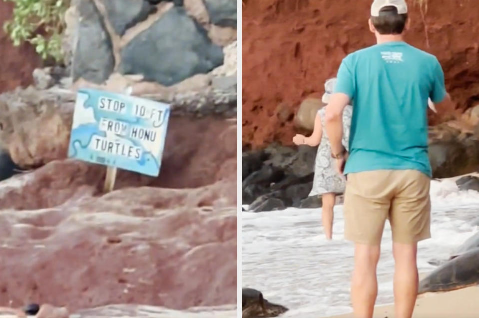 A man in shorts and a hat stands near a sign by the shore that reads 