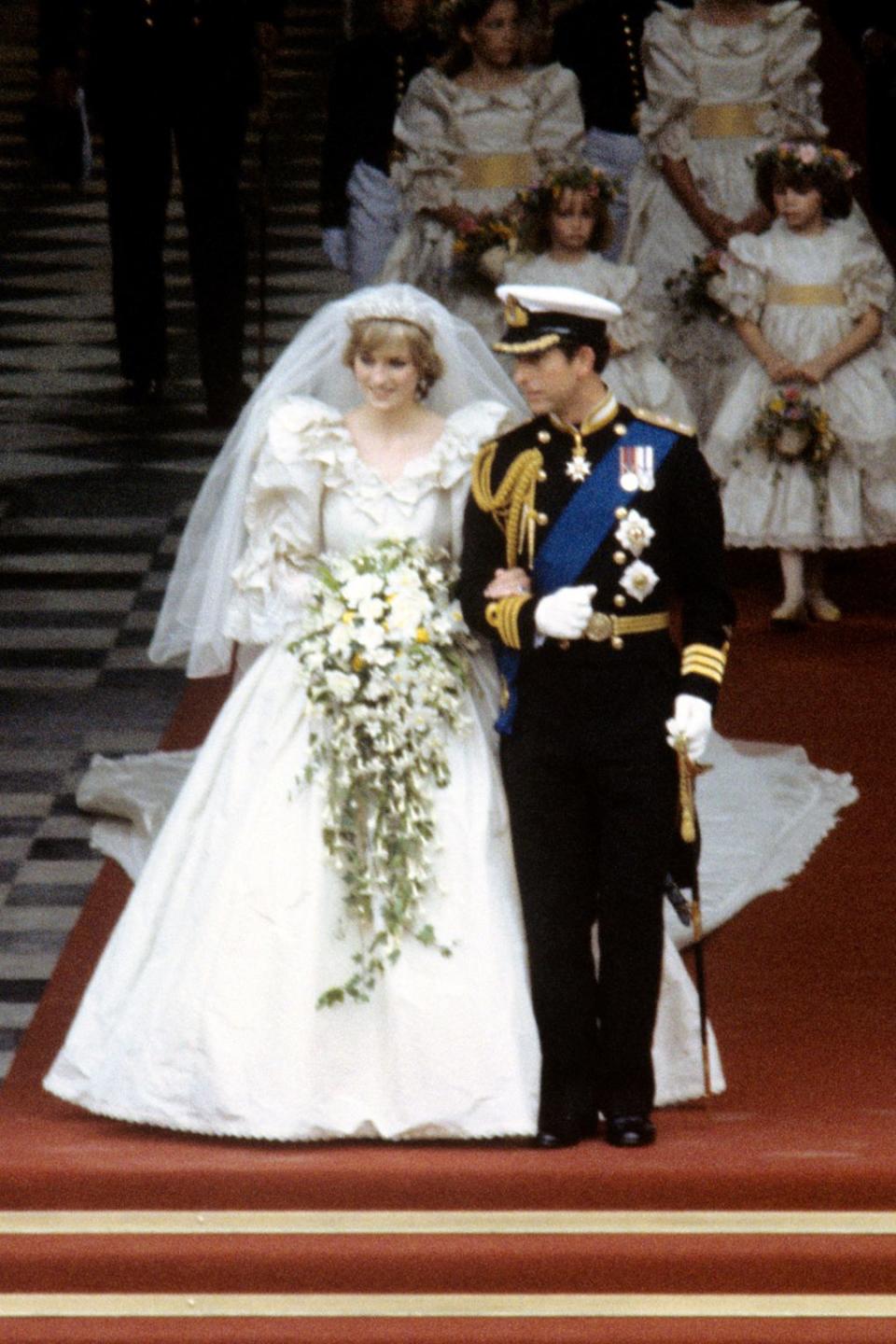 <p>Diana porta une robe imaginée par David et Elizabeth Emanuel pour son mariage, suivi par des millions de téléspectateurs, en juillet 1981 au Prince Charles. Sa traine d’environ huit mètres est la plus longue en date dans l’histoire des mariages royaux et continue d’influencer de nombreuses mariées. Crédit : Getty </p>