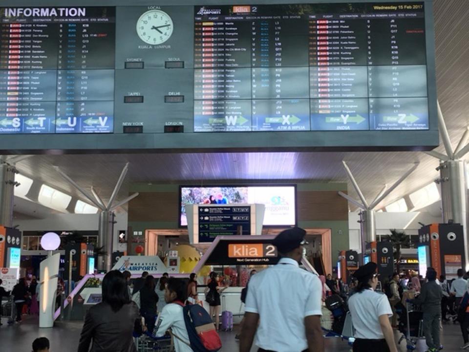 In this Wednesday, Feb. 15, 2017, photo, travelers pass through the low-budget airline terminal of Kuala Lumpur International Airport where North Korean Kim Jong Nam was reportedly assassinated in Kuala Lumpur, Malaysia. Malaysian police arrested a second woman Thursday in the death of Kim, the half brother of North Korea's leader who was reportedly poisoned this week by two female assassins as he waited for a flight in Malaysia. (AP Photo/Margie Mason)