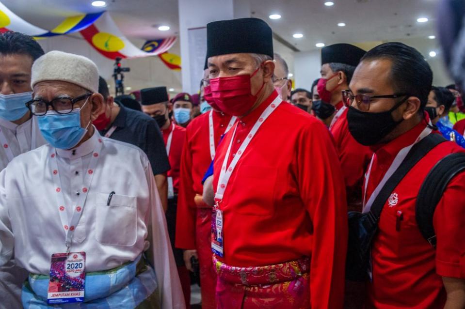 Umno president Datuk Seri Ahmad Zahid Hamidi (centre) arrives for the 2020 Umno general assembly in Kuala Lumpur March 28, 2021. — Picture by Shafwan Zaidon