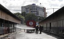 Sri Lankan workers wash a bus terminal during a curfew to prevent the spread of coronavirus in Colombo, Sri Lanka, Monday, Oct. 26, 2020. To contain the spread, the government has closed schools and banned gatherings across Sri Lanka, and a curfew is in effect in many parts of Western province, where the infections have been concentrated. (AP Photo/Eranga Jayawardena)