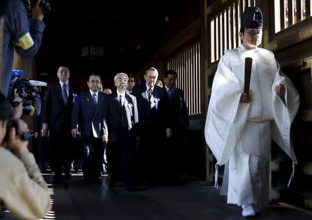 A group of lawmakers including Japan's ruling Liberal Democratic Party (LDP) lawmaker Hidehisa Otsuji (C) are led by a Shinto priest as they visit Yasukuni Shrine in Tokyo April 22, 2015.REUTERS/Toru Hanai