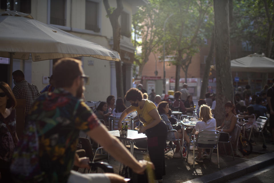 Customers sit at a terrace bar in Barcelona, Spain, Sunday, May 31, 2020. Spanish Prime Minister Pedro Sánchez says he will ask Spain's Parliament for a final two-week extension of the nation's state of emergency that has allowed the government to take lockdown measures to control its coronavirus outbreak. (AP Photo/Emilio Morenatti)