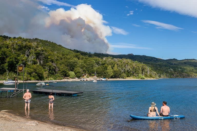 Turistas observan el humo del incendio, esta mañana