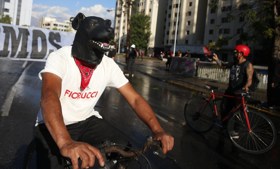 Un manifestante contra el gobierno maneja su bicicleta en la Plaza Italia después de un plebiscito para decidir si el país debe reemplazar su constitución de hace 40 años, redactada durante la última dictadura militar, en Santiago, Chile, el domingo 25 de octubre de 2020. (AP Foto/Luis Hidalgo)