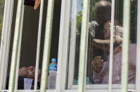 Patient Jose Silva, left, waits to be evacuated from the Bonsucesso Federal Hospital, which has a COVID-19 wing, as firefighters douse a blaze that broke out in Rio de Janeiro, Brazil, Tuesday, Oct. 27, 2020. According to the fire department, there were no casualties. (AP Photo/Silvia Izquierdo)