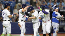 Tampa Bay Rays' Brandon Lowe, center, celebrates with teammates after hitting a grand slam off Toronto Blue Jays starting pitcher Chris Bassitt during the third inning of a baseball game Friday, March 29, 2024, in St. Petersburg, Fla. (AP Photo/Chris O'Meara)