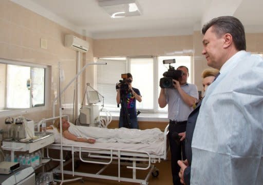 Ukrainian President Viktor Yanukovych speaks with a hospital patient in the Ukrainian city of Dnipropetrovsk. Yanukovych visited Ukraine's industrial heartland after a wave of blasts injured dozens of people ahead of the Euro 2012 football tournament