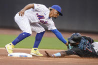 New York Mets' Francisco Lindor, left, tags out out Miami Marlins' Jesus Sanchez as he attempts to steal second base during the first inning in the first baseball game of a doubleheader Tuesday, Sept. 28, 2021, in New York. (AP Photo/Frank Franklin II)