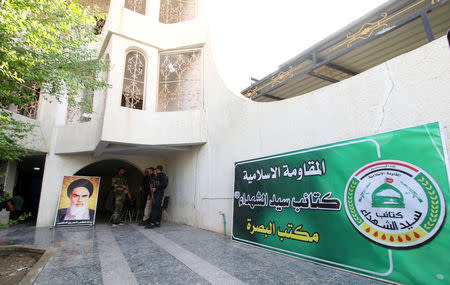 A poster of Iranian revolutionary leader Ayatollah Ruhollah Khomeini is seen outside the headquarters of a Shi'ite group Martyrs Movement in Basra, Iraq November 8, 2018. The text on the green banner reads 'Islamic Resistance, Kataib Sayyid al-Shuhada, Basra Office'. Picture taken November 8, 2018. To match Insight IRAQ-MILITIAS/ REUTERS/Essam al-Sudani