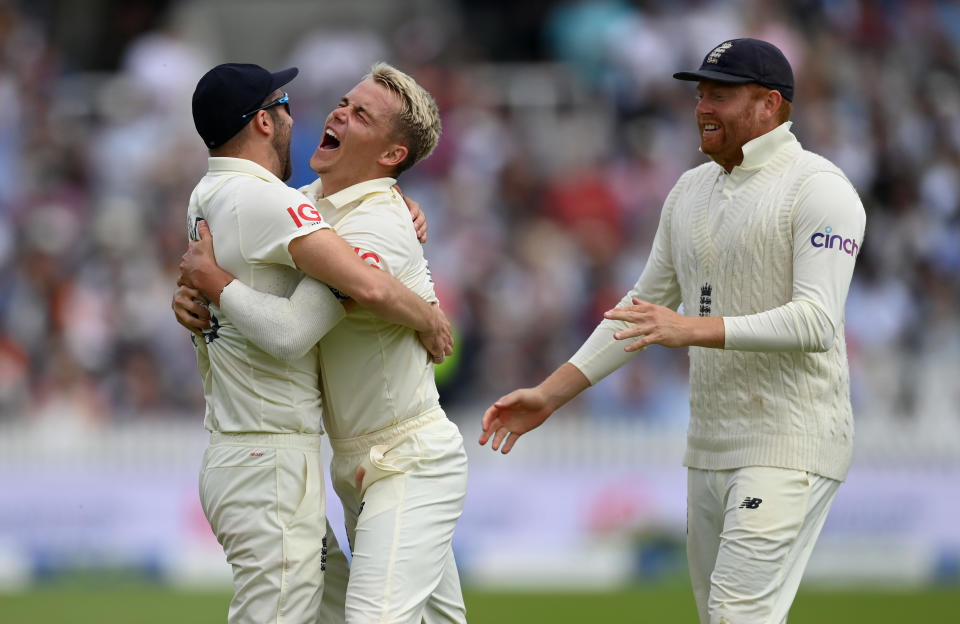 LONDON, ENGLAND - AUGUST 15: Sam Curran of England celebrates with Mark Wood and Jonathan Bairstow after dismissing India captain Virat Kohli during day four of the Second LV= Insurance Test Match between England and India at Lord's Cricket Ground on August 15, 2021 in London, England. (Photo by Gareth Copley/Getty Images)