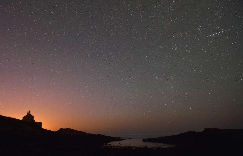 A star-filled night as a meteor is snapped streaking across the sky. 